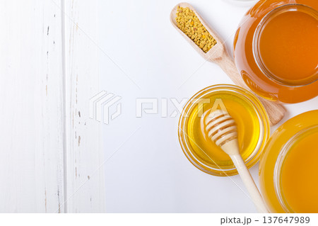 honey dipper and honey in jar on white background 137647989