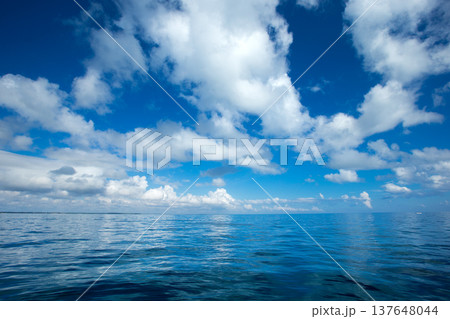 clouds on blue sky over calm sea with sunlight reflection clouds on blue sky over calm sea with sunlight reflection 137648044