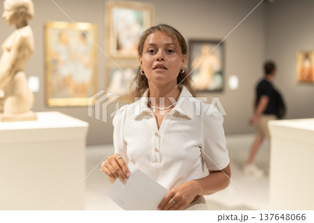 Girl walks around museum hall, view exhibition items 137648066