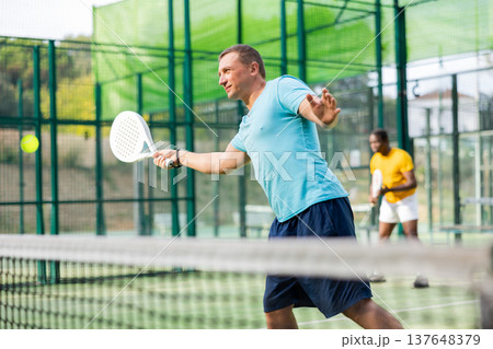 European man padel tennis player trains on the court European man padel tennis player trains on the court 137648379