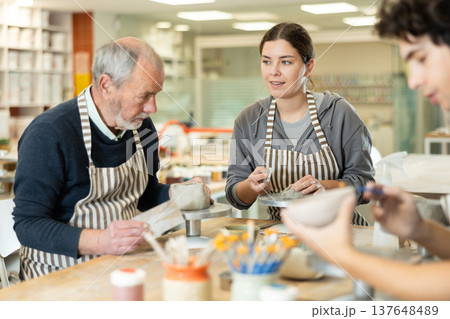 Young woman and man and elderly man crafting ceramics Young woman and man and elderly man crafting ceramics 137648489