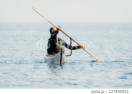 Kayaking Paddling Ocean - A kayaker paddles through the ocean, using a long oar to propel their boat. Kayaking Paddling Ocean - A kayaker paddles through the ocean, using a long oar to propel their boat. 137648932