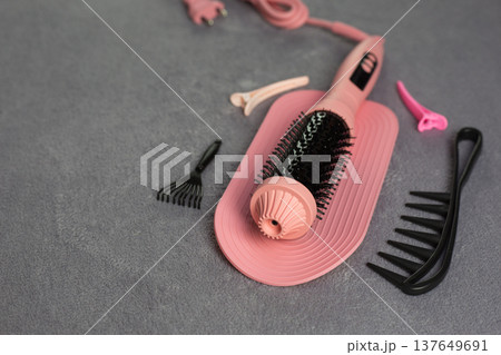 Romantic pink electric hair styler set for perfect date night look. Complete with round brush, comb, and clips helps create gorgeous curls and waves. Essential beauty tool for special evening 137649691