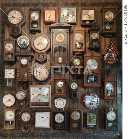 A decorative wall filled with antique and vintage clocks mounted on an aged wooden surface, showcasing historic timepieces and classic interior decoration A decorative wall filled with antique and vintage clocks mounted on an aged wooden surface, showcasing historic timepieces and classic interior decoration 137650196
