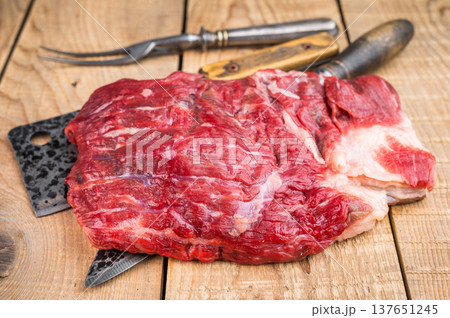 Raw beef brisket on rustic wooden table with butcher tools, overhead meat preparation scene with copy space Raw beef brisket on rustic wooden table with butcher tools, overhead meat preparation scene with copy space 137651245