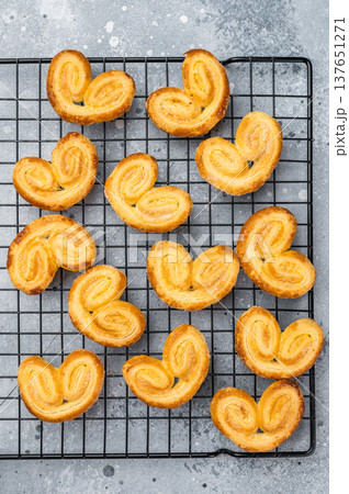 Sweet puff pastry palmiers cooling on wire rack gray stone background flaky buttery bakery cookies with copy space 137651271