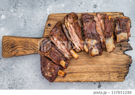 Cut roasted lamb ribs slab bone in with crispy crust on board gourmet barbecue food top view 137651280