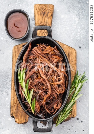 Slow cooked shredded brisket, juicy BBQ beef in rustic pan, top view food photo with copyspace for menu or recipe. Slow cooked shredded brisket, juicy BBQ beef in rustic pan, top view food photo with copyspace for menu or recipe. 137651288