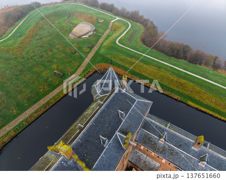 Top-down aerial view of the medieval Muiderslot castle courtyard and towers. Close-up drone shot of the historic fortress, moat, and formal gardens in Muiden, Netherlands, on a misty day. 137651660