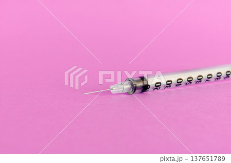 Medical syringe with needle isolated on a vibrant pink background for cosmetic beauty procedures. Close-up studio shot of a sterile disposable syringe used for facial injections, filler treatments Medical syringe with needle isolated on a vibrant pink background for cosmetic beauty procedures. Close-up studio shot of a sterile disposable syringe used for facial injections, filler treatments 137651789