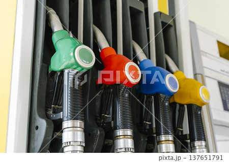 Fuel pump nozzles hanging at a modern gas station during a period of high oil prices. A conceptual photography showcasing the global energy crisis, increasing gasoline costs 137651791