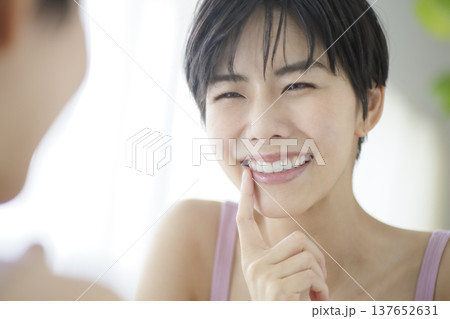 日常生活を送る若い女性 鏡を見ながら歯をチェックする 137652631