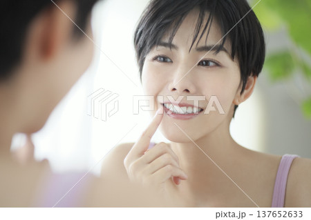 日常生活を送る若い女性 鏡を見ながら口腔ケアの確認 137652633