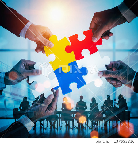 Conceptual double e puzzle pieces being joined together in a business meeting setting during sunset hours 137653816