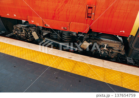 Train wheels and undercarriage view at a busy railway station during the day 137654759