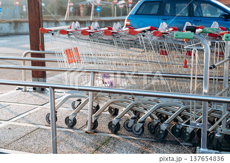 Shopping carts lined up at a parking area near a store in the early morning hours Shopping carts lined up at a parking area near a store in the early morning hours 137654836