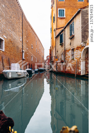 Quiet canal view with boats and buildings in Venice during the day 137654915