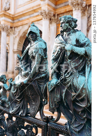 Statues of figures sitting on a railing in a historical location during daytime Statues of figures sitting on a railing in a historical location during daytime 137654992