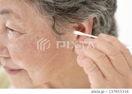 綿棒で耳掃除をするシニア女性 137655316