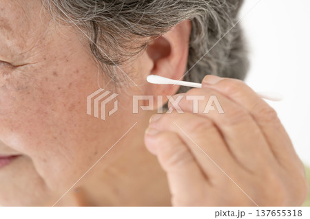 綿棒で耳掃除をするシニア女性 綿棒で耳掃除をするシニア女性 137655318