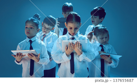 Children studying with tablets in neon studio for digital learning advertising 137655687