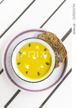 yellow organic pumpkin soup bowl with sourdough toast on restaurant white table outddor yellow organic pumpkin soup bowl with sourdough toast on restaurant white table outddor 137655733