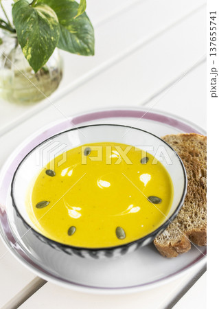 yellow organic pumpkin soup bowl with sourdough toast on restaurant white table outddor yellow organic pumpkin soup bowl with sourdough toast on restaurant white table outddor 137655741