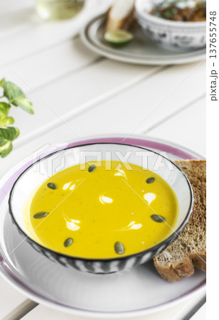 yellow organic pumpkin soup bowl with sourdough toast on restaurant white table outddor yellow organic pumpkin soup bowl with sourdough toast on restaurant white table outddor 137655748