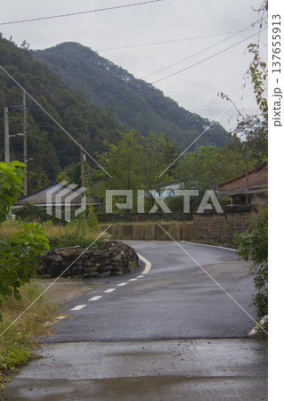 This is a rural road scene on a cloudy day. This is a rural road scene on a cloudy day. 137655913