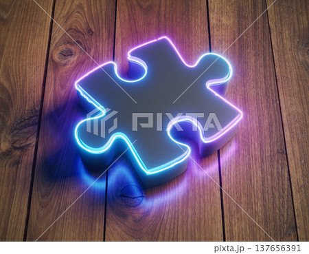 Colorful neon puzzle piece sits on wooden surface with warm tones and soft glow in indoor setting during evening light 137656391