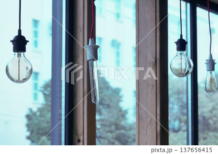 Vintage light bulbs suspended from a wire. Hanging retro incandescent lamps. The view from the window. closeup of photo Vintage light bulbs suspended from a wire. Hanging retro incandescent lamps. The view from the window. closeup of photo 137656415