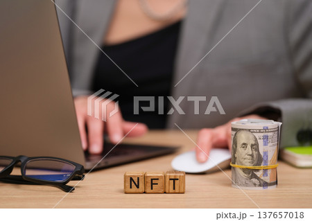 Engaging in digital finance with NFTs and cash on a modern workspace desk 137657018