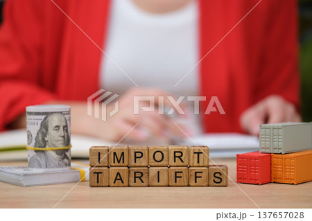 Exploring the impact of import tariffs on global trade at a busy workspace in a modern office setting Exploring the impact of import tariffs on global trade at a busy workspace in a modern office setting 137657028