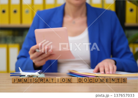Preparing important immigration documents while seated at an organized desk with a model airplane 137657033