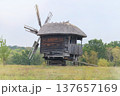 Old wooden mill. Authentic house in vintage style. Installation in museums of traditional retro style. Windmill. Sunny day. 137657169