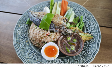Thai fried rice with shrimp paste, topped with fried mackerel, vegetables, and egg. Thai fried rice with shrimp paste, topped with fried mackerel, vegetables, and egg. 137657492