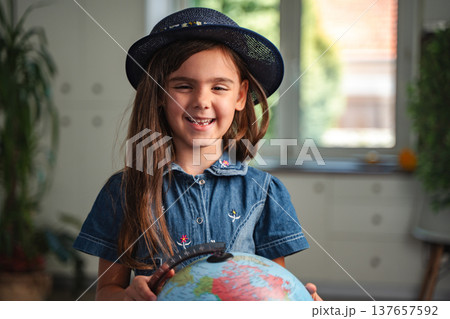 Smiling student holding a globe is learning geography 137657592