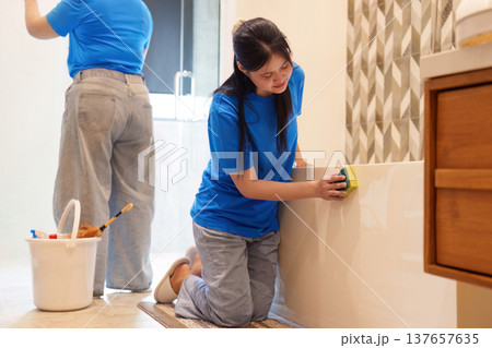 Bathroom Cleaning. Young woman scrubbing the tub with a sponge. Bathroom Cleaning. Young woman scrubbing the tub with a sponge. 137657635
