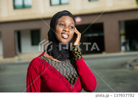 close up of young muslim woman with mobile phone, smiling. 137657782