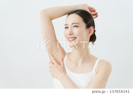 白背景の脇に手を当てて微笑む若い日本人女性 脱毛イメージ 白背景の脇に手を当てて微笑む若い日本人女性 脱毛イメージ 137658141