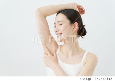 白背景の脇に手を当てて微笑む若い日本人女性 脱毛イメージ 白背景の脇に手を当てて微笑む若い日本人女性 脱毛イメージ 137658142
