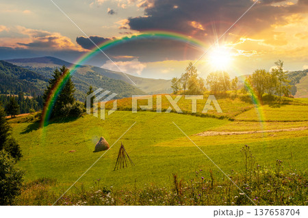 pastoral rural landscape with field on hill at sunset. alpine scenery with traditional haystack in evening light. mountainous countryside hayfield during summer. hope, expectation and bright future pastoral rural landscape with field on hill at sunset. alpine scenery with traditional haystack in evening light. mountainous countryside hayfield during summer. hope, expectation and bright future 137658704