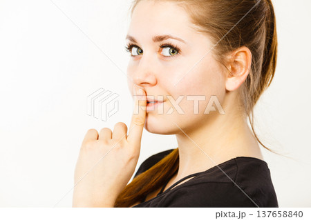 Woman showing silence gesture with finger Woman showing silence gesture with finger 137658840