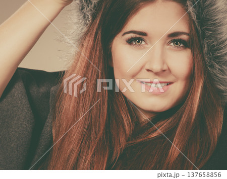 Happy woman wearing dark poncho coat with hood Happy woman wearing dark poncho coat with hood 137658856
