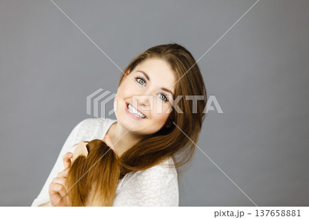 Happy woman brushing her hair 137658881
