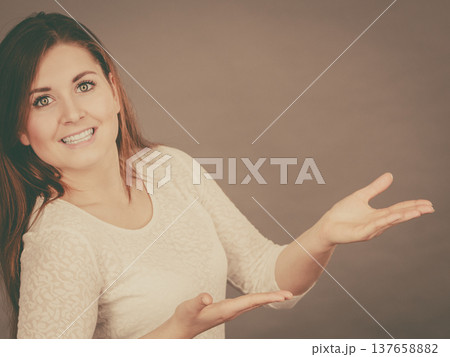 Happy woman presenting copyspace with hands 137658882