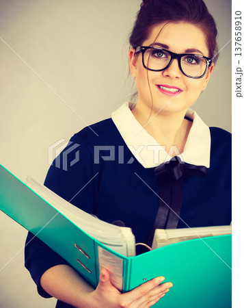 Happy positive business woman holding binder with documents Happy positive business woman holding binder with documents 137658910