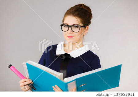 Happy positive business woman holding binder with documents Happy positive business woman holding binder with documents 137658911