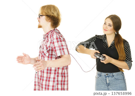 Woman controling man using gaming pad Woman controling man using gaming pad 137658996