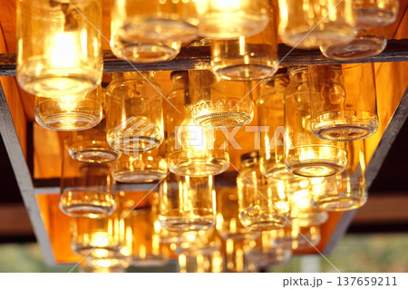 Vintage glass jars on the ceiling in the store in the evening. Light through the glass of the jar. Vintage glass jars on the ceiling in the store in the evening. Light through the glass of the jar. 137659211